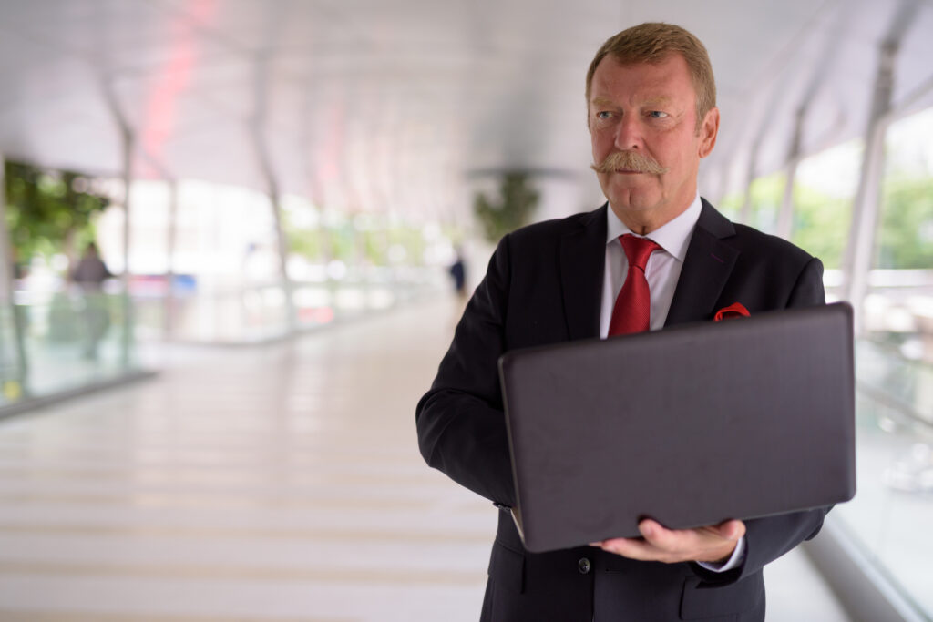 Portrait of handsome senior businessman with mustache relaxing at the footbridge in the city of Bangkok Thailand Portrait of handsome senior businessman with mustache relaxing at the footbridge in the city of Bangkok Thailand